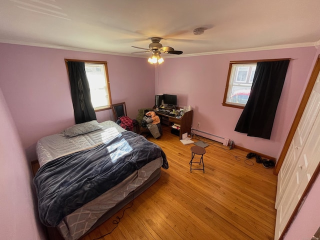 bedroom with a baseboard radiator, ornamental molding, ceiling fan, and light wood-type flooring