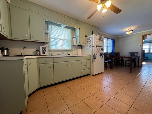 kitchen with white refrigerator, ornamental molding, plenty of natural light, and green cabinetry