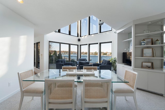 carpeted dining room featuring built in features and a high ceiling