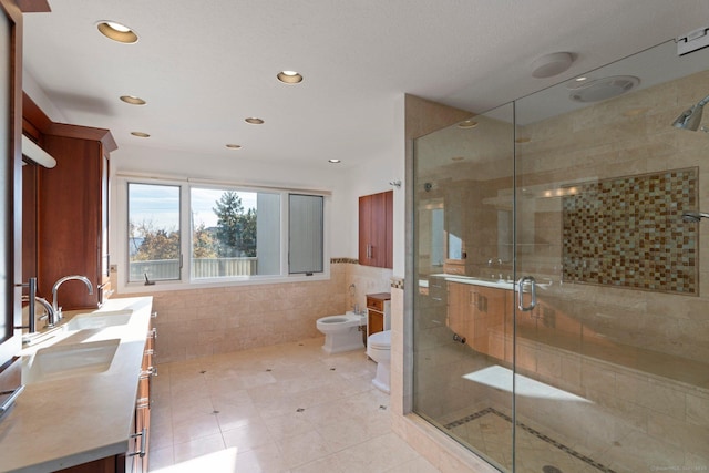 bathroom featuring walk in shower, toilet, tile walls, a bidet, and vanity