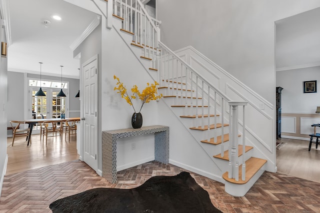 stairs with ornamental molding, recessed lighting, brick floor, and baseboards