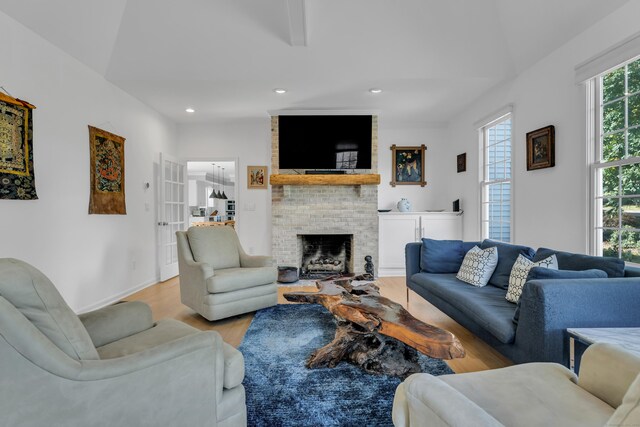 living room with a brick fireplace and light hardwood / wood-style floors