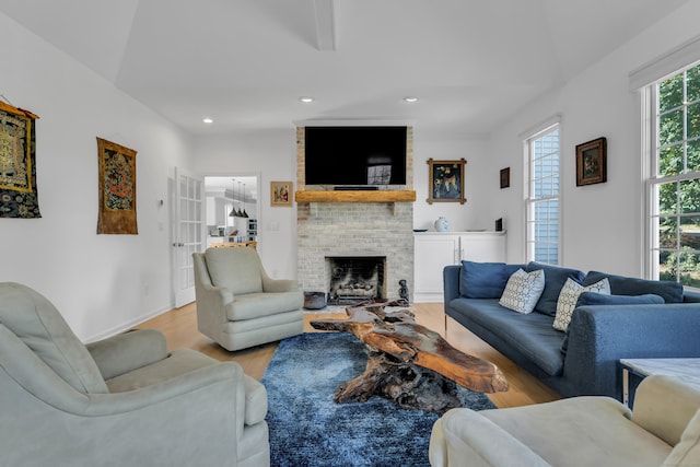 living room with light wood-style floors, recessed lighting, a brick fireplace, and baseboards