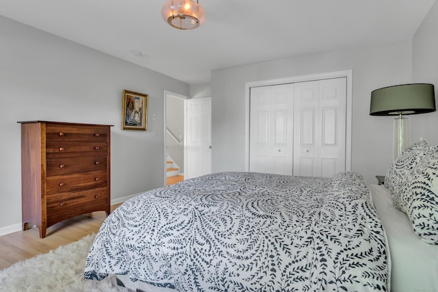 bedroom with light hardwood / wood-style floors and a closet