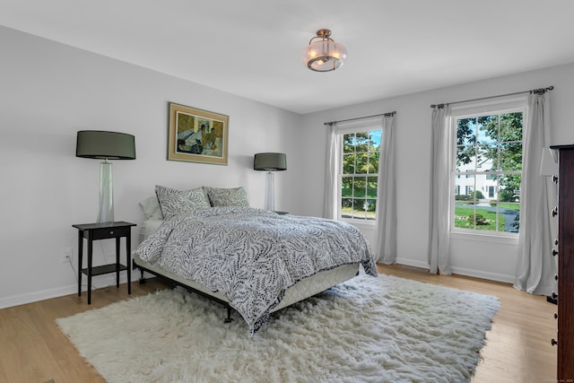 bedroom with baseboards and wood finished floors