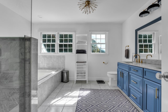 bathroom with toilet, tile patterned floors, vanity, and tiled bath