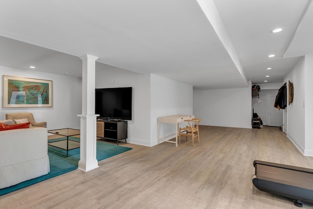 interior space featuring baseboards, recessed lighting, light wood-type flooring, and ornate columns