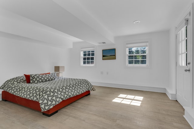 bedroom with visible vents, light wood-style flooring, and baseboards