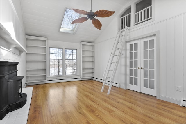 unfurnished living room featuring built in shelves, light wood-type flooring, and french doors