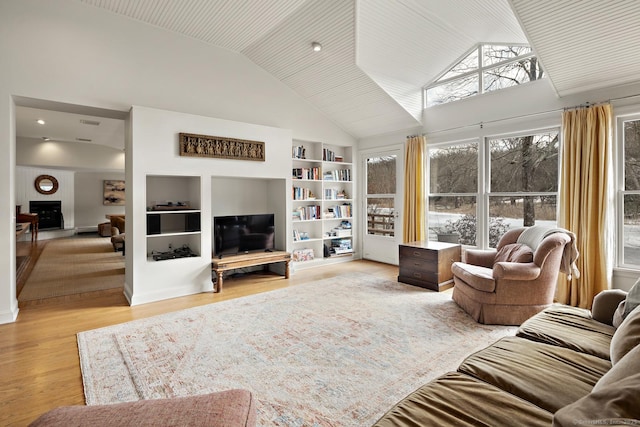 living room featuring high vaulted ceiling, built in features, and light wood-type flooring