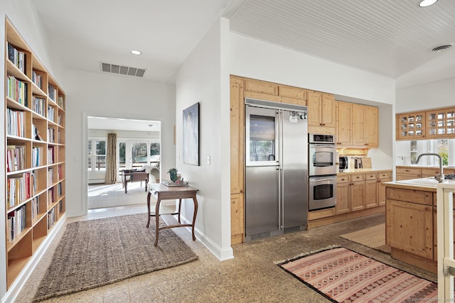 kitchen with light brown cabinetry, sink, and stainless steel appliances