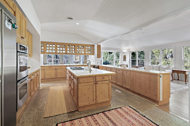 kitchen featuring lofted ceiling, sink, a center island with sink, wooden ceiling, and appliances with stainless steel finishes