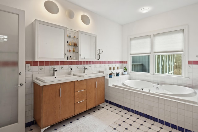 bathroom with vanity, tiled bath, and tile walls