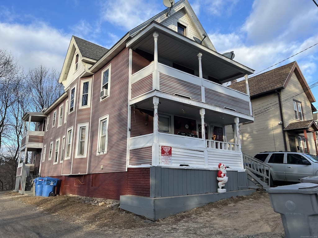 view of front of house featuring cooling unit, a balcony, and covered porch