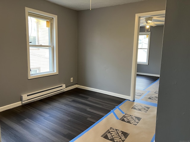 unfurnished room with dark wood-style floors, ceiling fan, a baseboard radiator, and baseboards