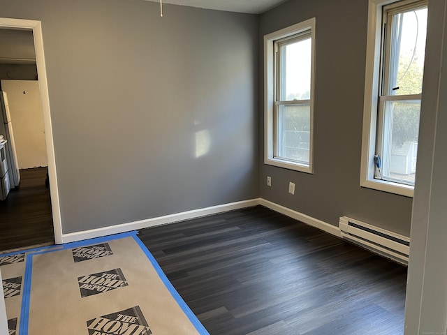 empty room with baseboards, baseboard heating, and dark wood-style flooring