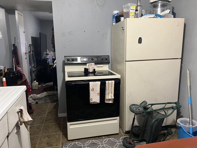 kitchen with freestanding refrigerator, electric stove, and tile patterned flooring