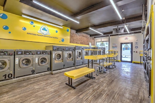 clothes washing area featuring hardwood / wood-style flooring and washing machine and dryer