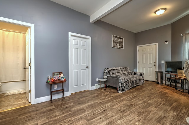 sitting room featuring dark wood-type flooring and beamed ceiling