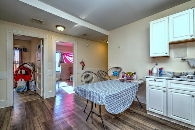 kitchen featuring white cabinetry and dark wood-type flooring