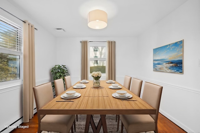 dining room with a baseboard radiator and dark hardwood / wood-style floors