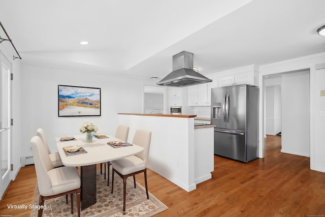 dining space with a baseboard heating unit and hardwood / wood-style flooring