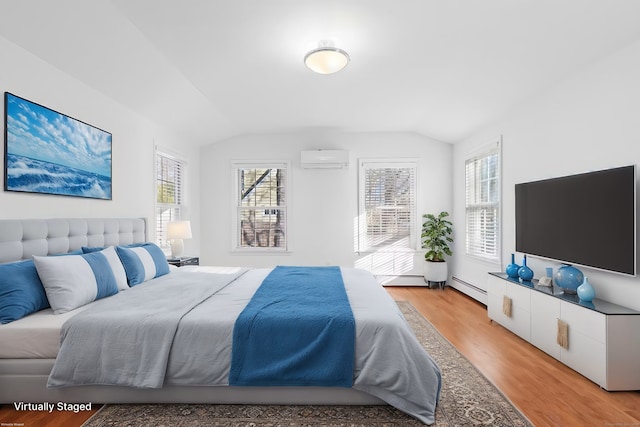 bedroom with lofted ceiling, a wall mounted AC, light hardwood / wood-style flooring, and a baseboard heating unit