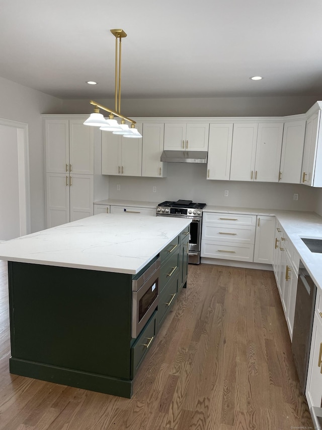 kitchen featuring appliances with stainless steel finishes, a kitchen island, hanging light fixtures, and white cabinets