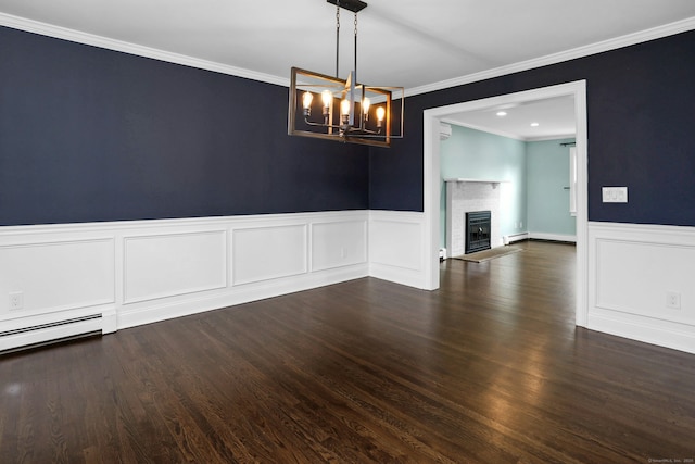 unfurnished room featuring a wainscoted wall, ornamental molding, a brick fireplace, and wood finished floors