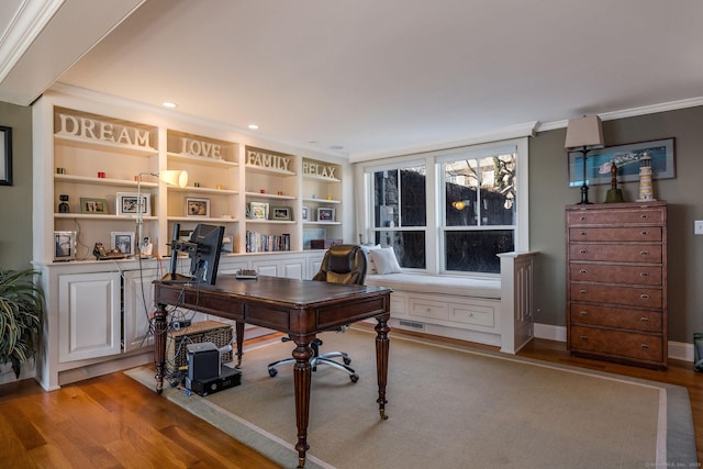 office area with ornamental molding, light hardwood / wood-style floors, and built in shelves