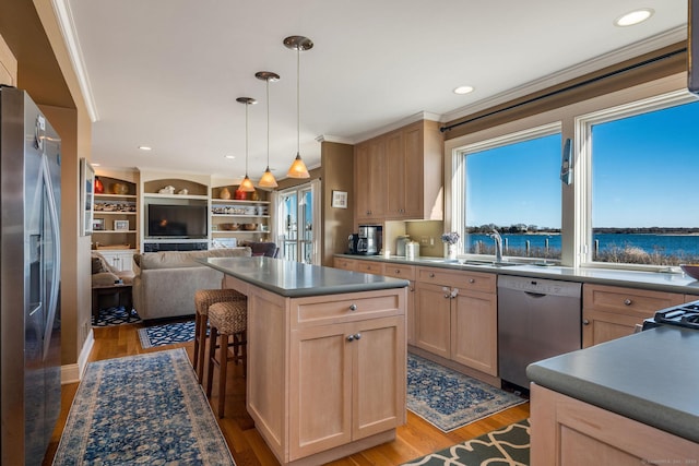 kitchen with stainless steel appliances, light hardwood / wood-style floors, and light brown cabinets