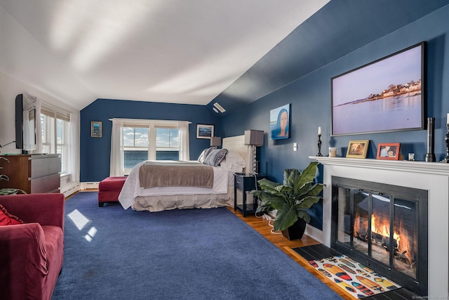 bedroom featuring vaulted ceiling, dark hardwood / wood-style floors, and access to outside