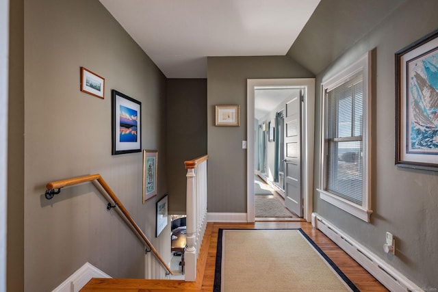 interior space featuring hardwood / wood-style flooring, vaulted ceiling, and baseboard heating