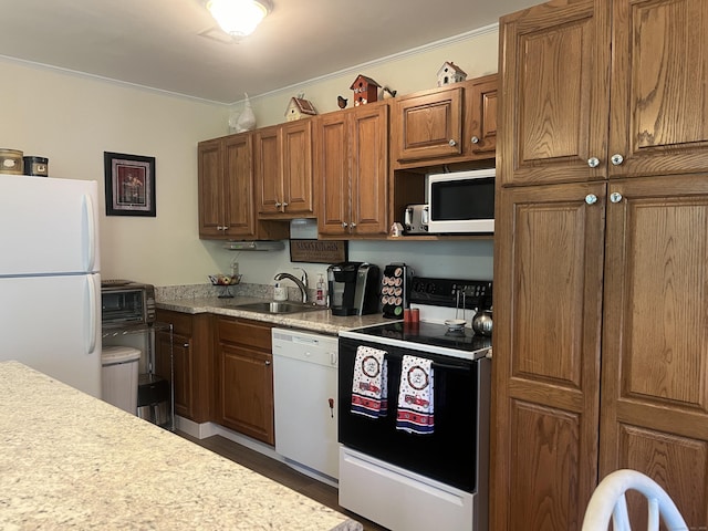 kitchen with sink, white appliances, dark wood-type flooring, and ornamental molding