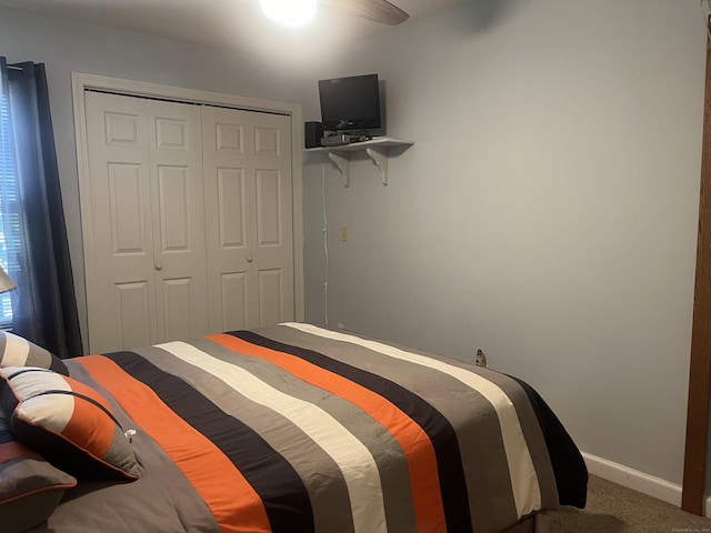 carpeted bedroom with ceiling fan and a closet