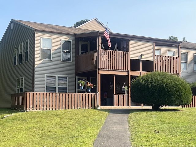 view of front of home featuring a balcony and a front yard