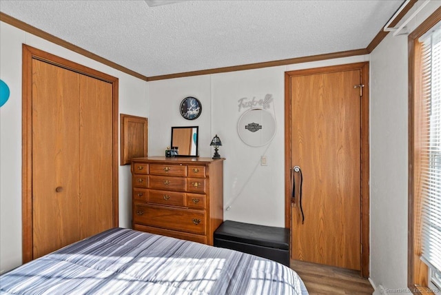 bedroom with hardwood / wood-style flooring, ornamental molding, a textured ceiling, and a closet