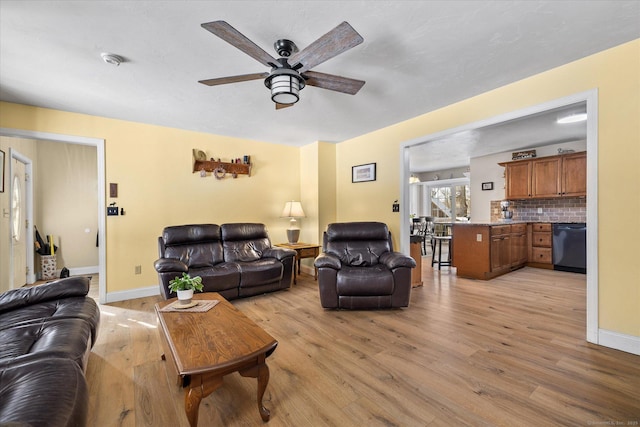 living room featuring ceiling fan and light hardwood / wood-style flooring