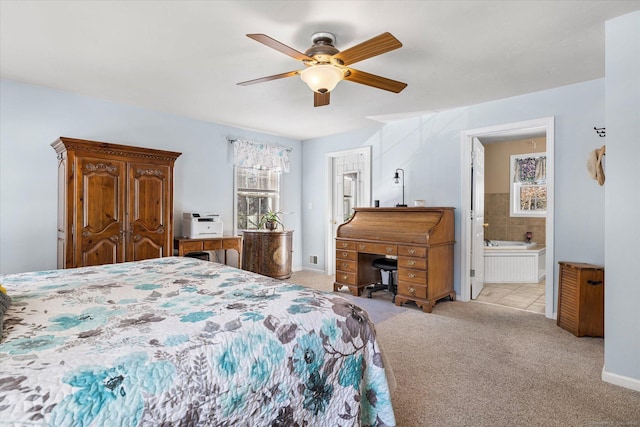 bedroom with ceiling fan, ensuite bath, and light colored carpet