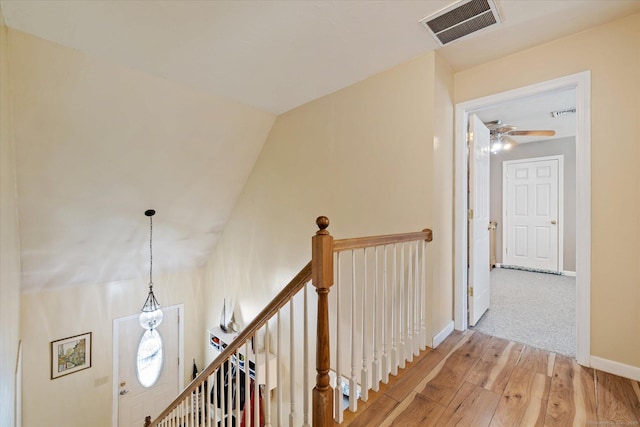 hall featuring lofted ceiling and light hardwood / wood-style flooring