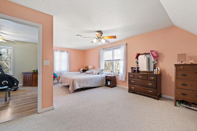 bedroom with ceiling fan, vaulted ceiling, and light carpet