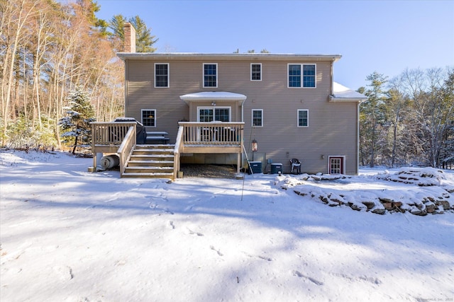 snow covered house with a wooden deck