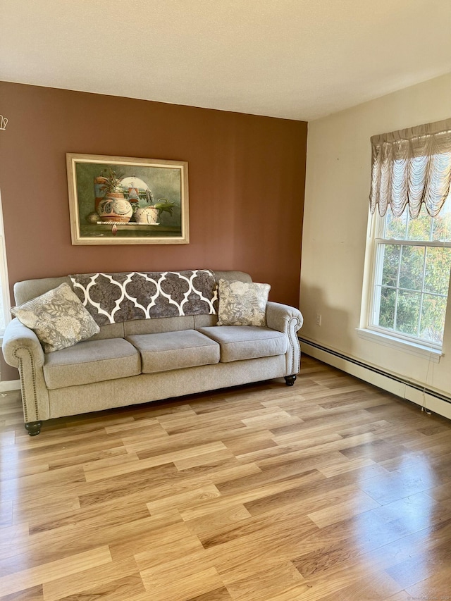 living room with baseboard heating and light hardwood / wood-style floors