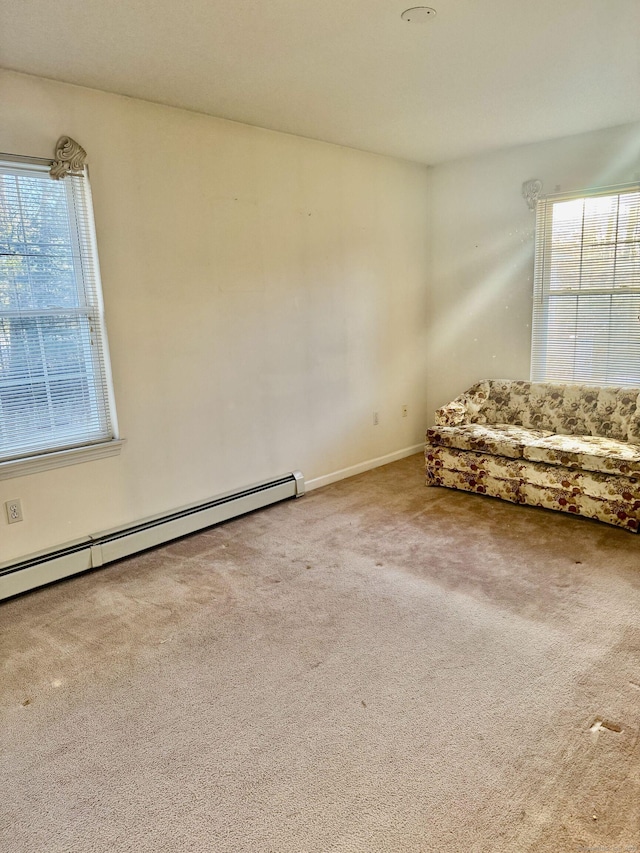 unfurnished room with baseboard heating and carpet