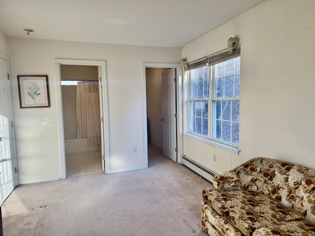 living area featuring baseboard heating, light colored carpet, and a textured ceiling