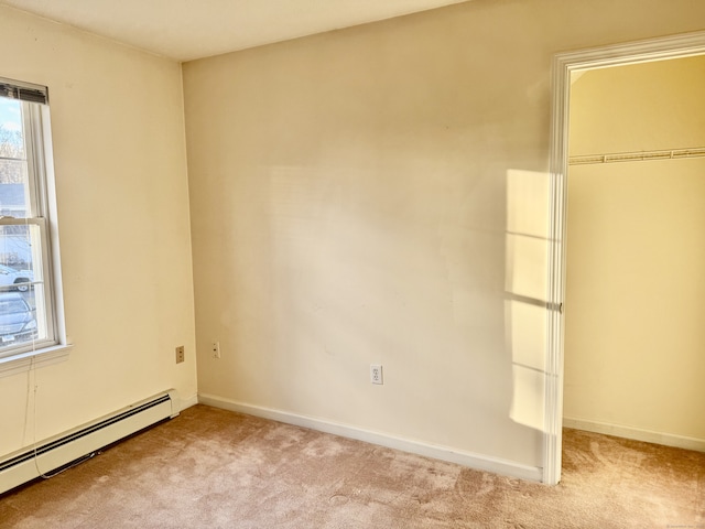 interior space featuring multiple windows, light colored carpet, a closet, and baseboard heating