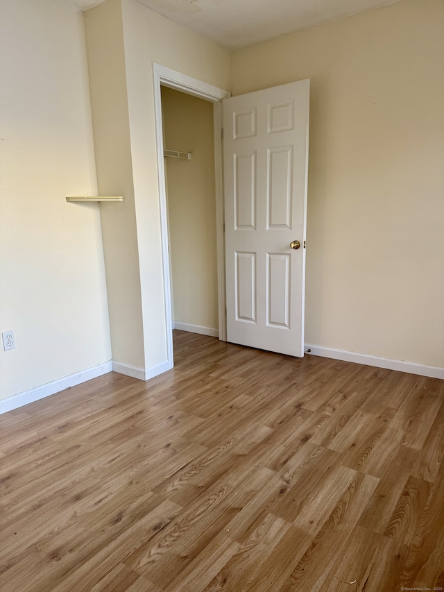 unfurnished bedroom with a closet and light wood-type flooring