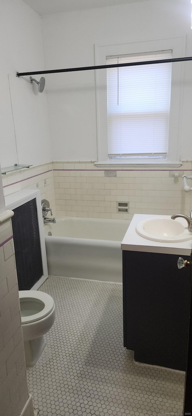 bathroom with tile patterned flooring, a bathing tub, vanity, and toilet