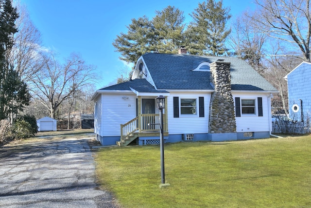 view of front facade with a garage, an outdoor structure, and a front yard