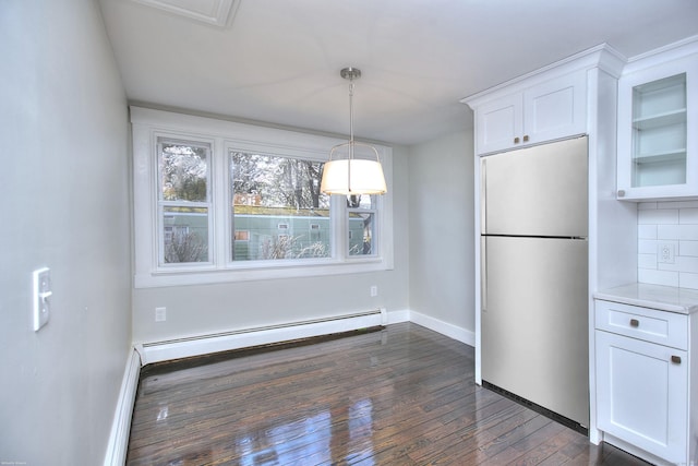 unfurnished dining area with dark wood-type flooring and a baseboard radiator